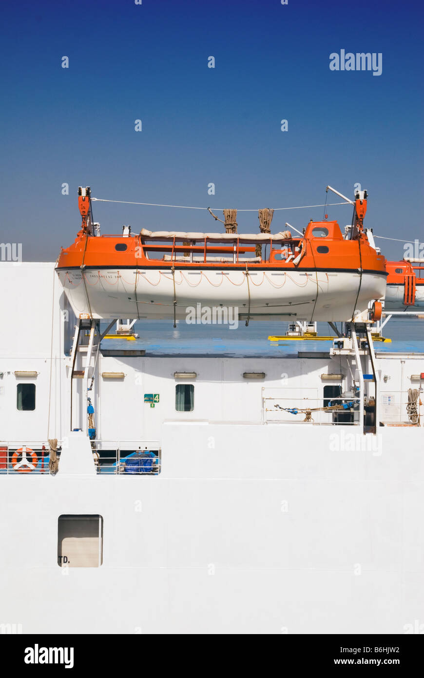 White and orange lifeboat securely held in place by davits on a ferry Stock Photo