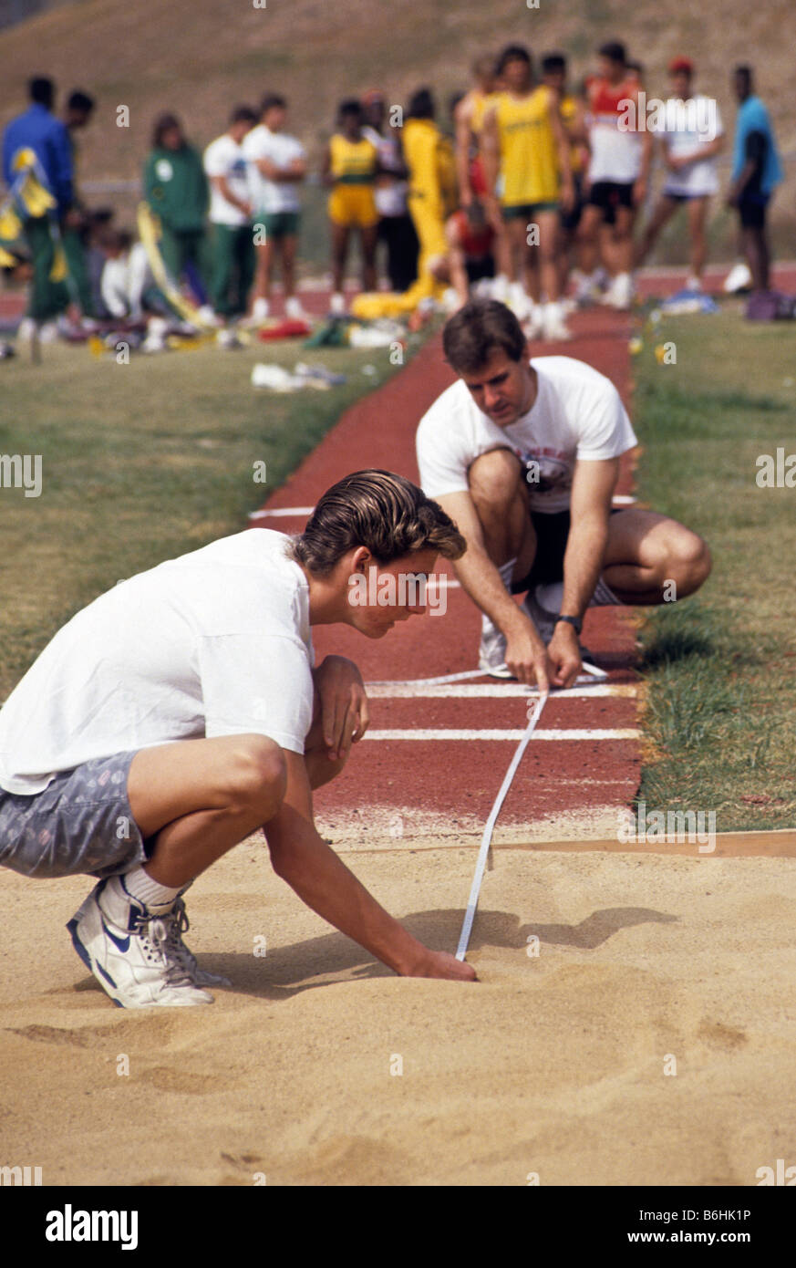 Official And Athlete Measure Marks To Show Distance Of His Jump During 