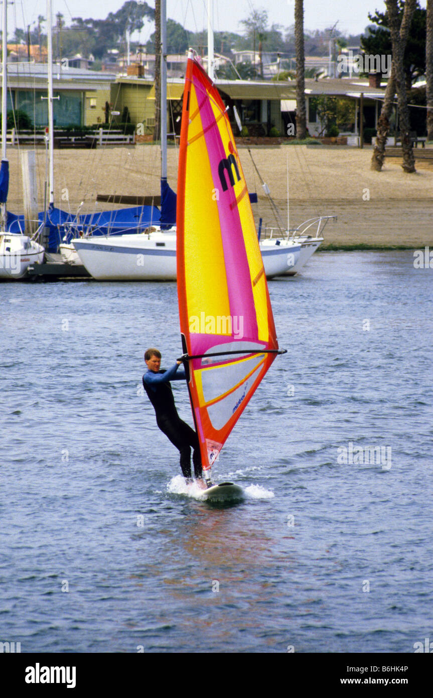 Windsurfer rides board on smooth waters of Newport Bay in southern California. Stock Photo