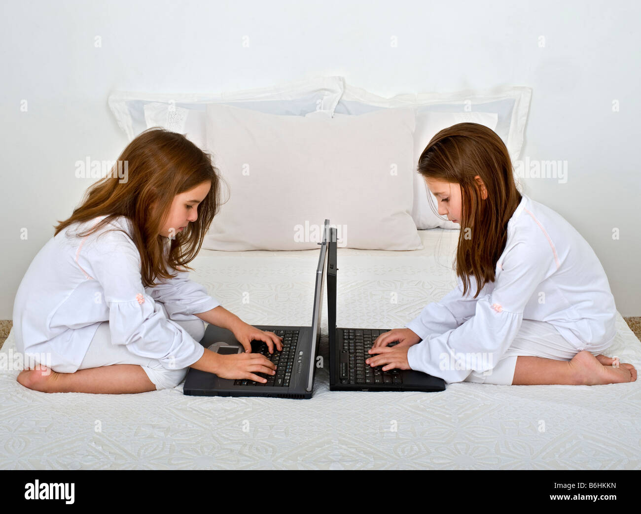 two girls with laptop computers on the bed Stock Photo Alamy