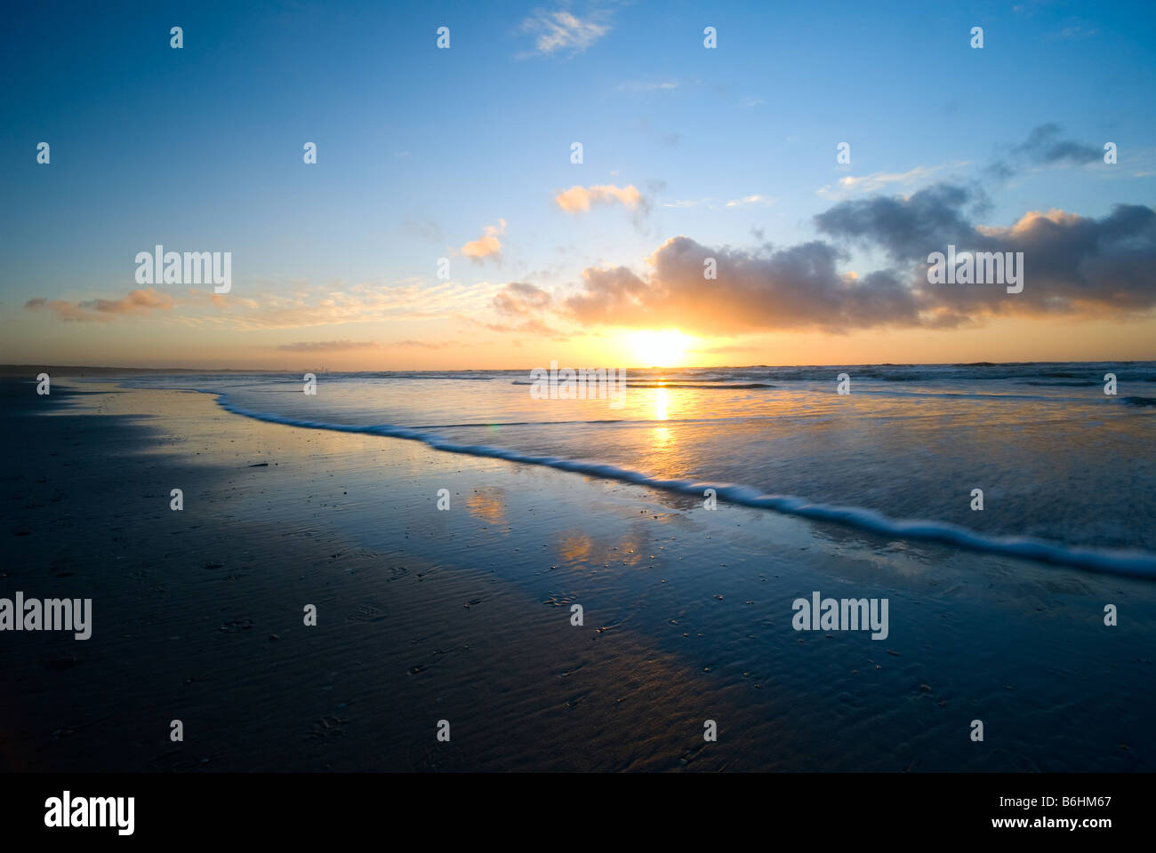 beautiful sunset and waves on the beach Stock Photo - Alamy