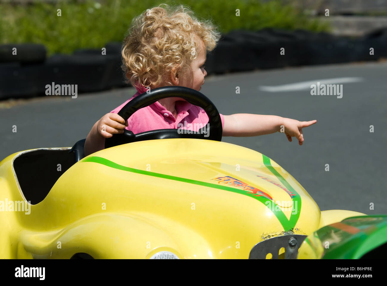 cute young boy having fun in yellow car Stock Photo