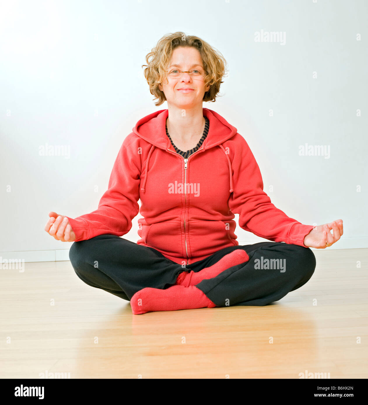woman sitting on a parquet floor meditating Stock Photo - Alamy