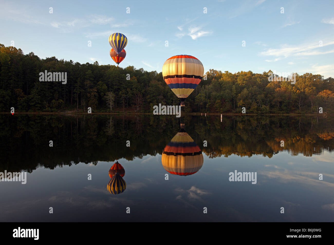 A group of hot air balloons hover above the waters of the Rivanna River