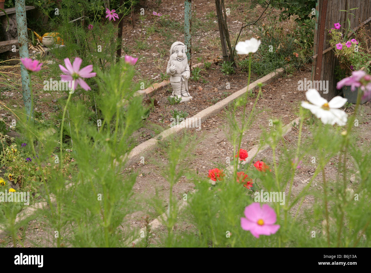 Gnome in garden of flowers, France Stock Photo