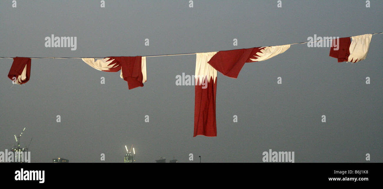 Qatari flags on a wire against grey evening sky, Doha, Qatar, Middle East Stock Photo