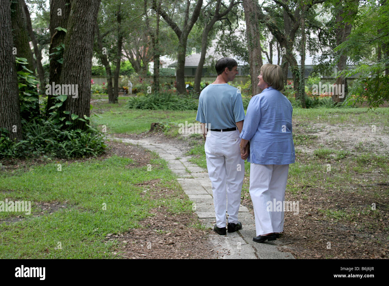 Couple walking through park holding hi-res stock photography and images ...
