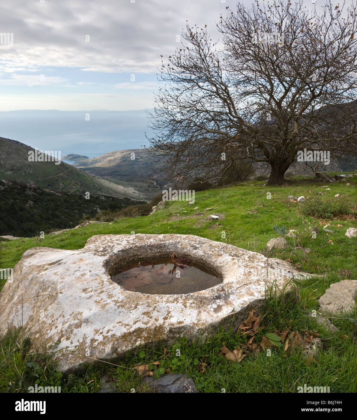 Stone trough on a montain pasture overlooking the gulf of Messinia above Trachila, Outer Mani, Southern Peloponnese, Greece Stock Photo