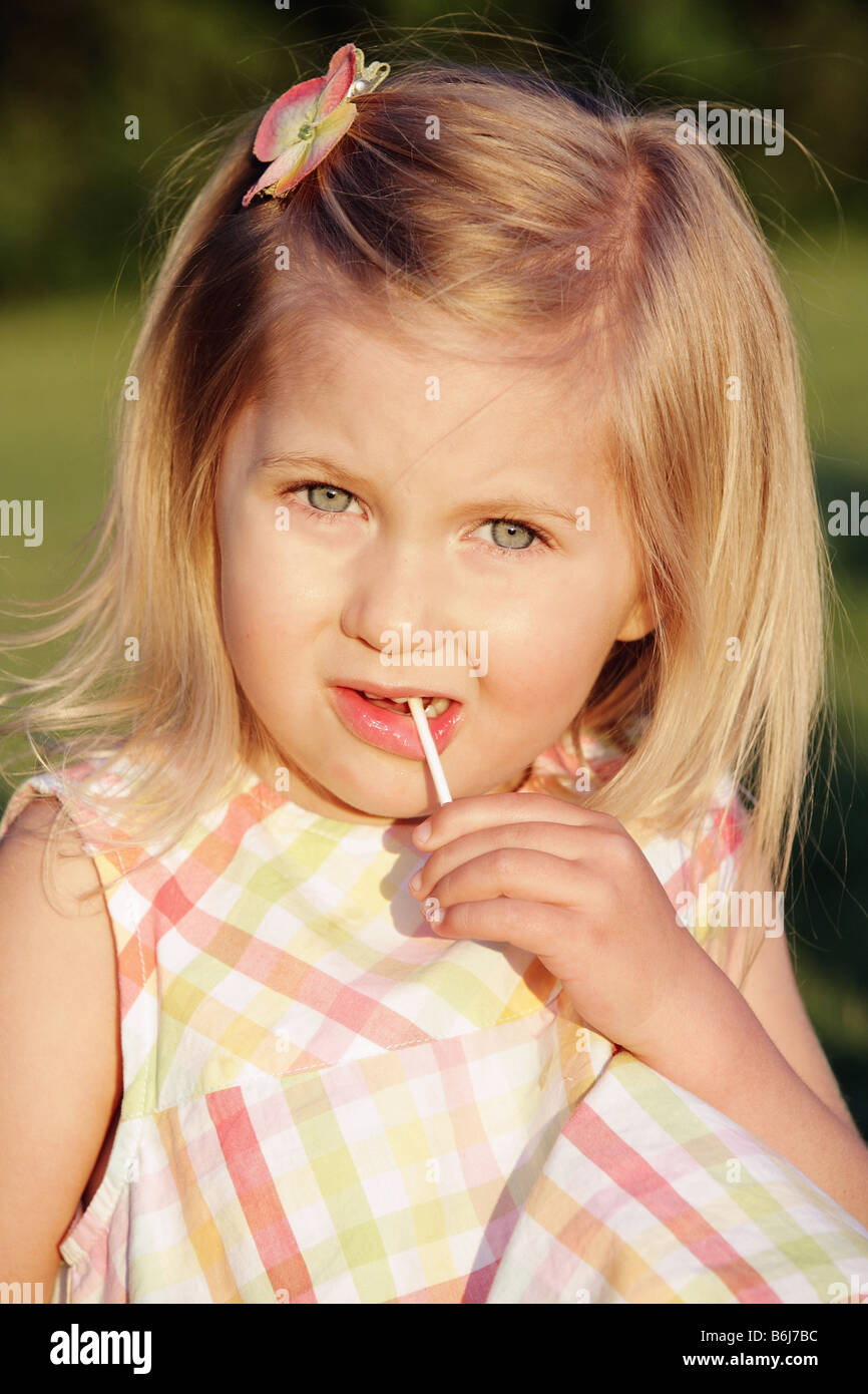 cute little blond girl eating a candy sucker Stock Photo