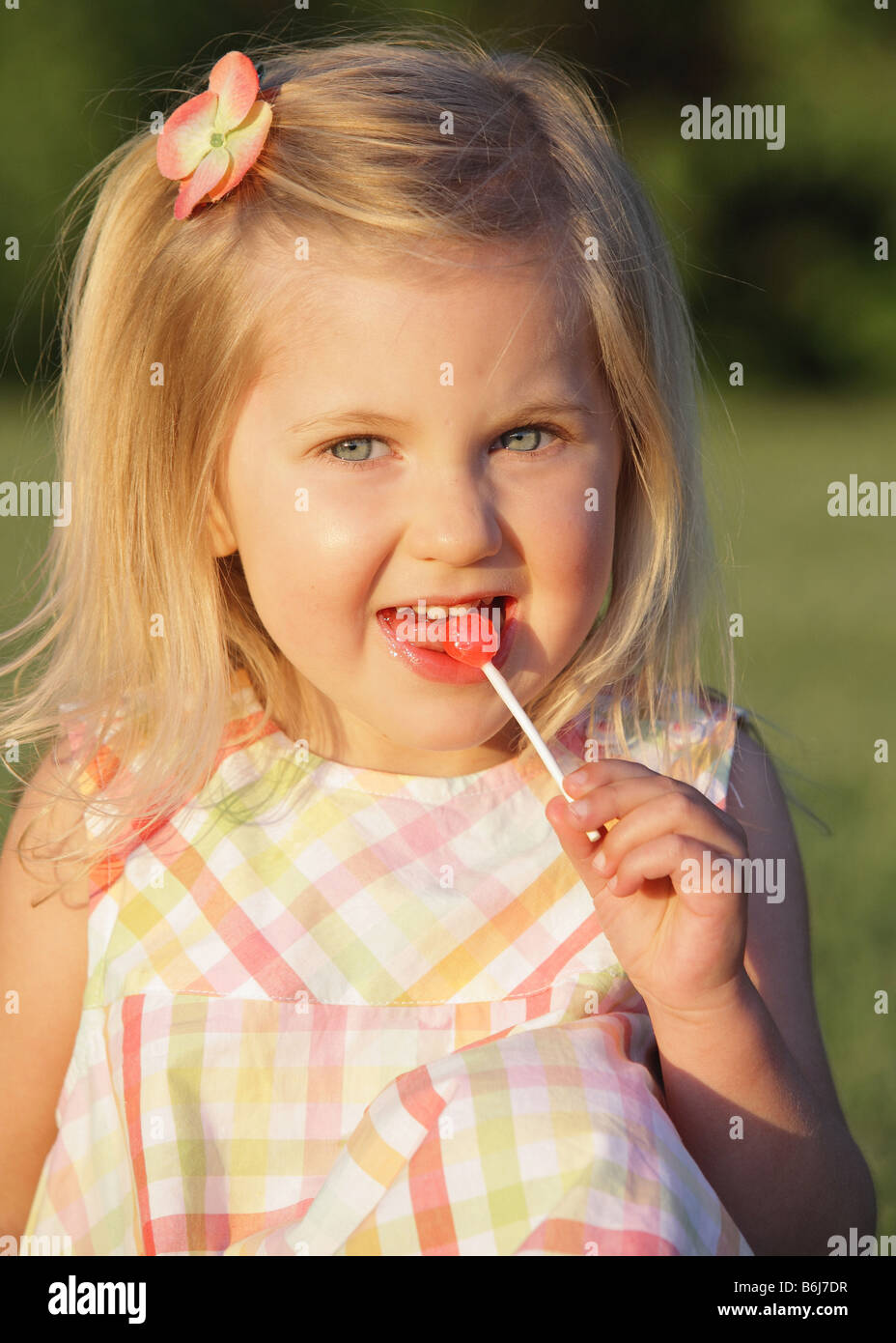 happy little girl eating candy outside Stock Photo