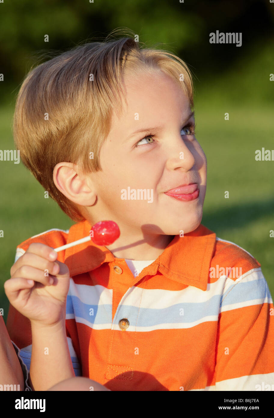 happy young boy tasting a candy sucker outdoor Stock Photo