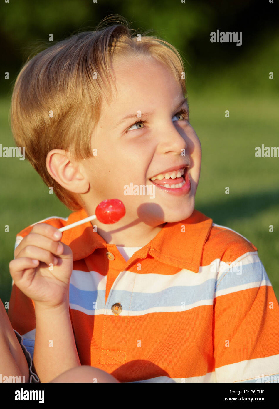 happy young white boy eating a sucker Stock Photo