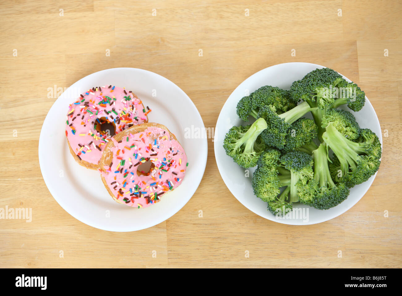 Plates of broccoli and donuts Stock Photo