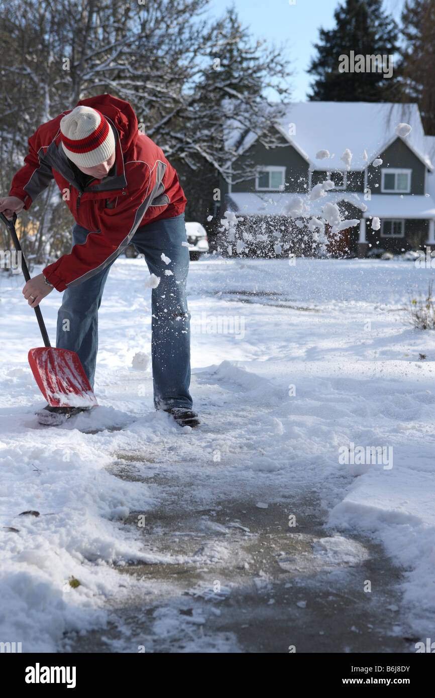 Man in winter shoveling snow off sidewalk Stock Photo