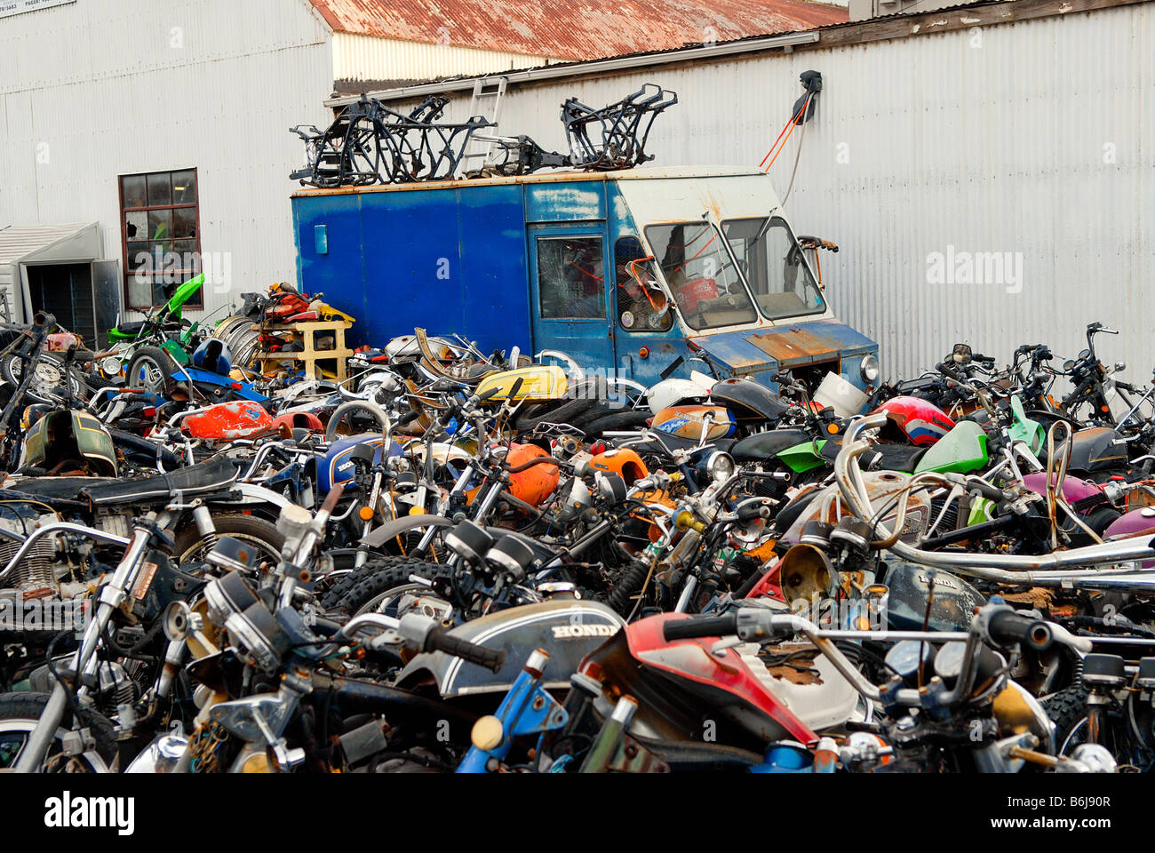 Old motorcycle parts, along with an old blue milk truck, make up a junkyard  mostly dedicated to motorcycle parts Stock Photo - Alamy