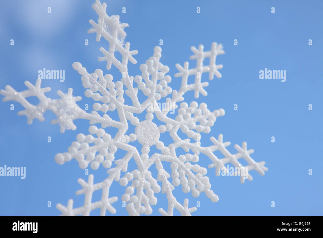 Snowflake ornament against blue winter sky Stock Photo