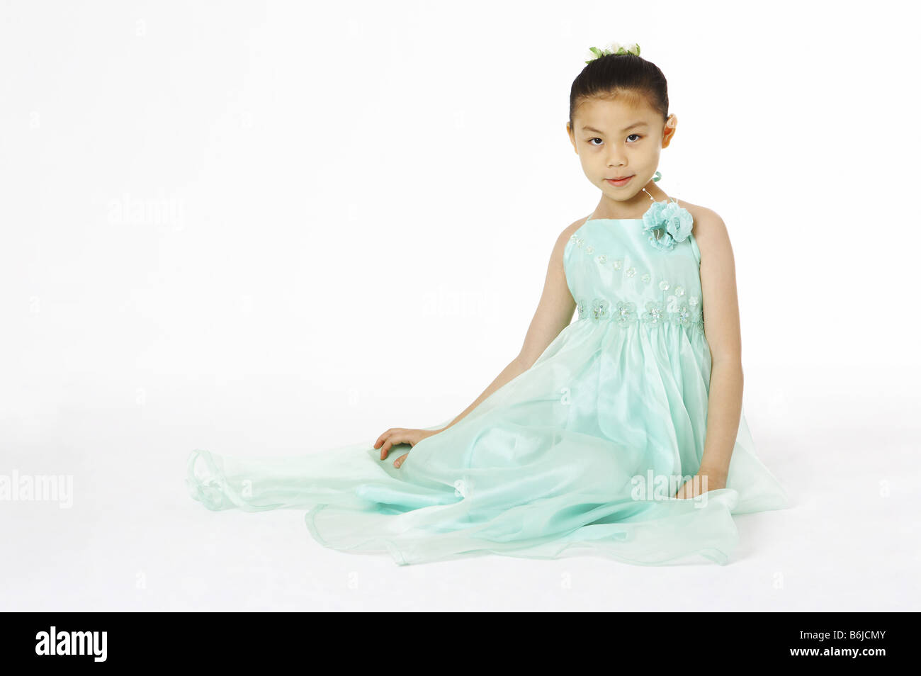 Girl in green skirt sitting on the floor Stock Photo - Alamy