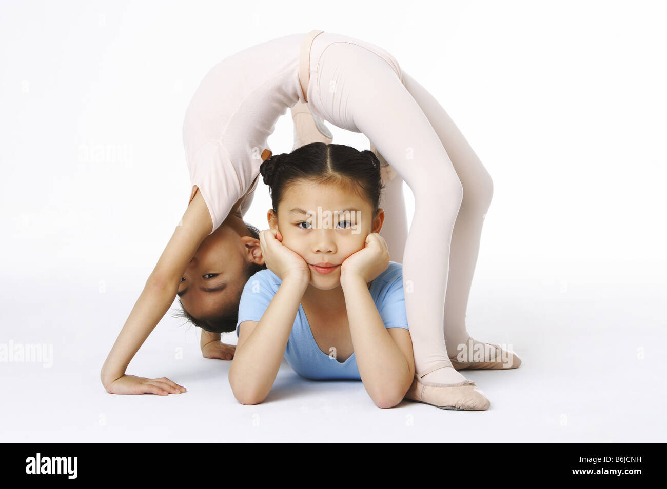 One girl bend down her body over the other girl Stock Photo - Alamy