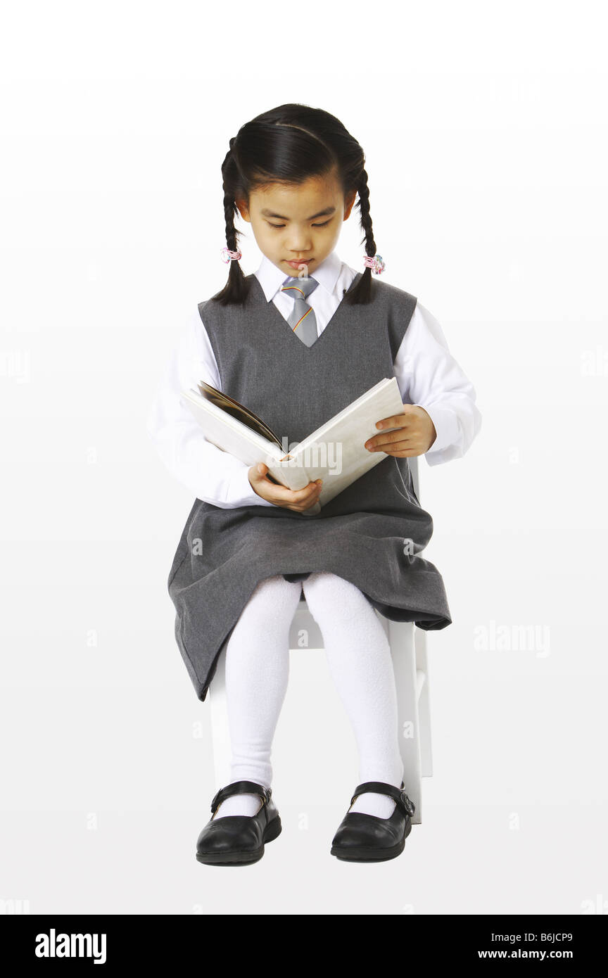 Girl sitting on the chair reading a book Stock Photo Alamy