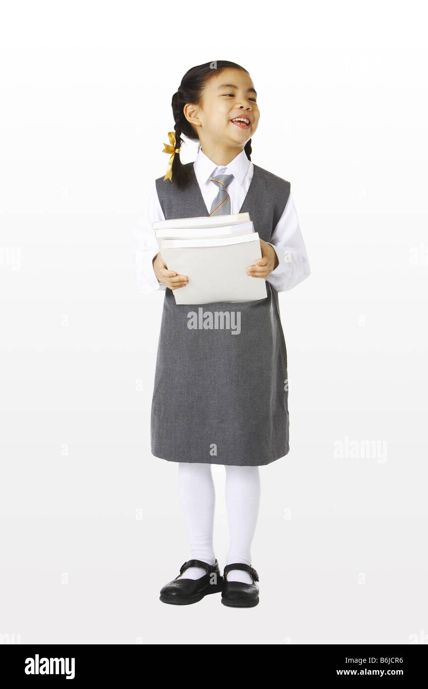 Girl in school uniforms holding three books Stock Photo - Alamy