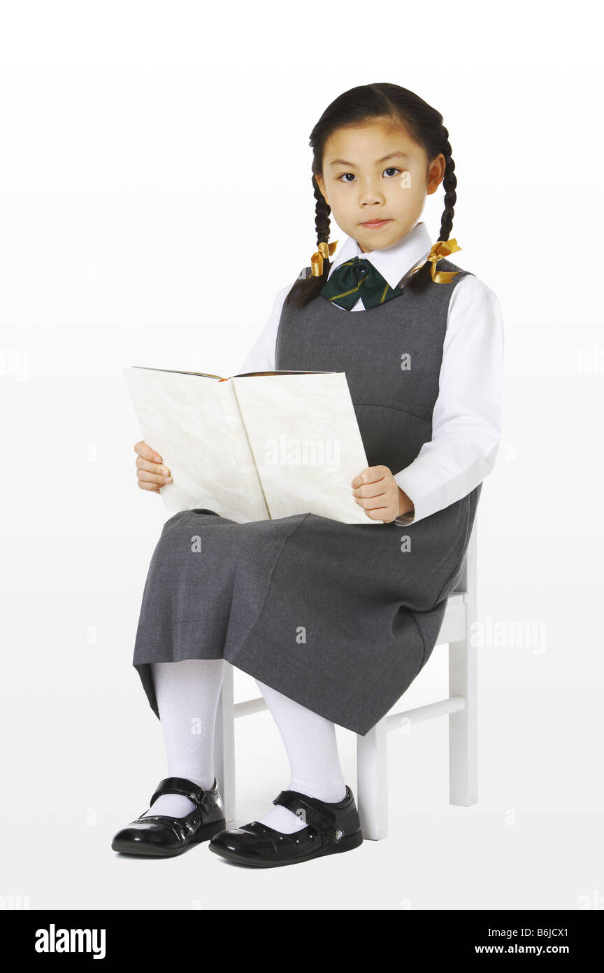 Girl sitting on the chair holding a book Stock Photo - Alamy