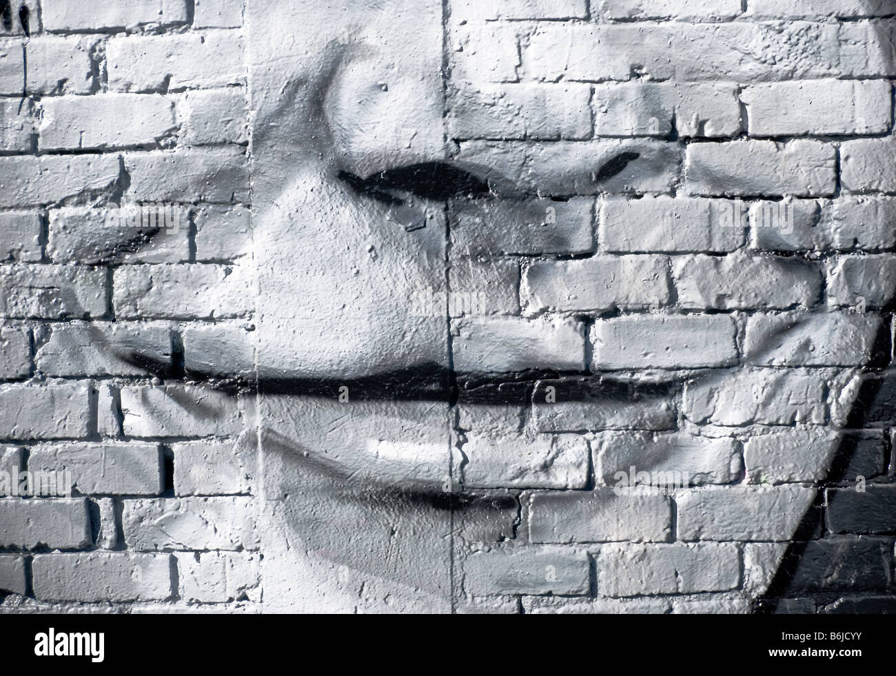 Graffiti:smiling face on the textured brick wall Stock Photo