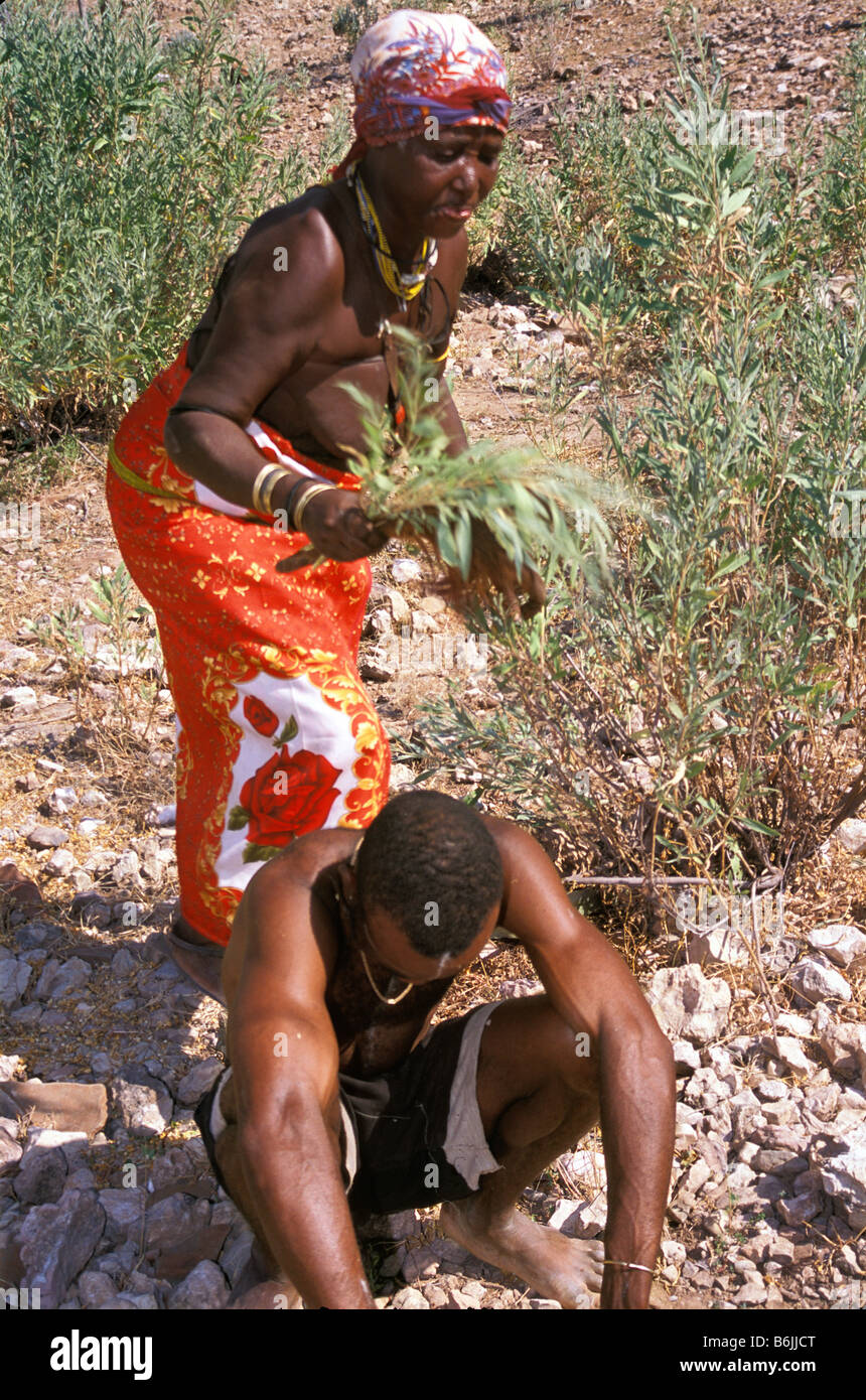 A witch doctor of the Himba tribe heals a man in the bush near Opuwo, Namibia. Stock Photo