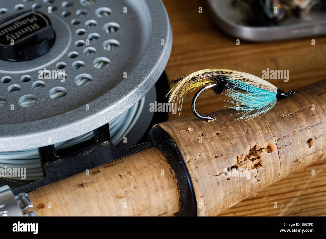 UK.  A salmon fly stuck into the cork handle of a fly fishing rod. Stock Photo
