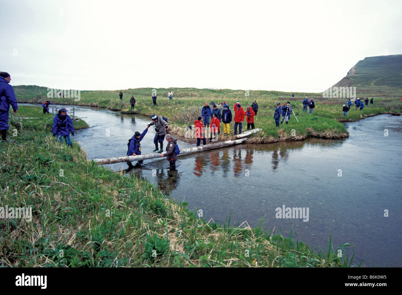 Crew members helping cruise members crossing bridge to see Vitus Bering's grave on Bering Island, Komandorski Islands, Sibera Stock Photo