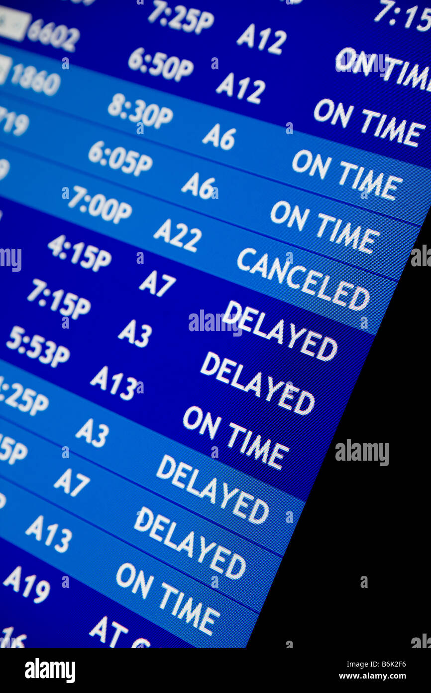 Airline flight schedule board at an airport showing delays and flight cancellations Stock Photo