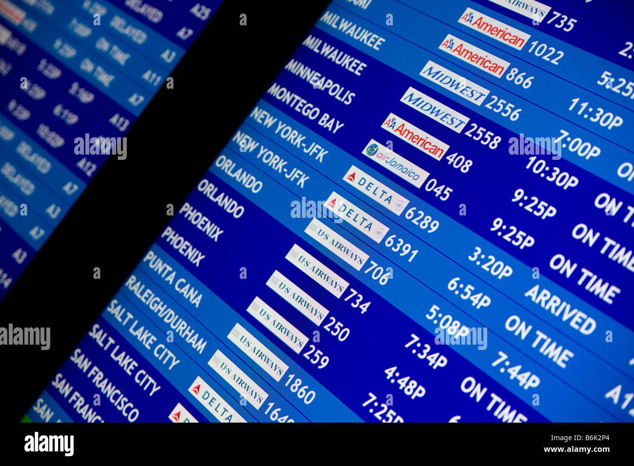 Airline flight schedule board at an airport showing delays and flight cancellations Stock Photo