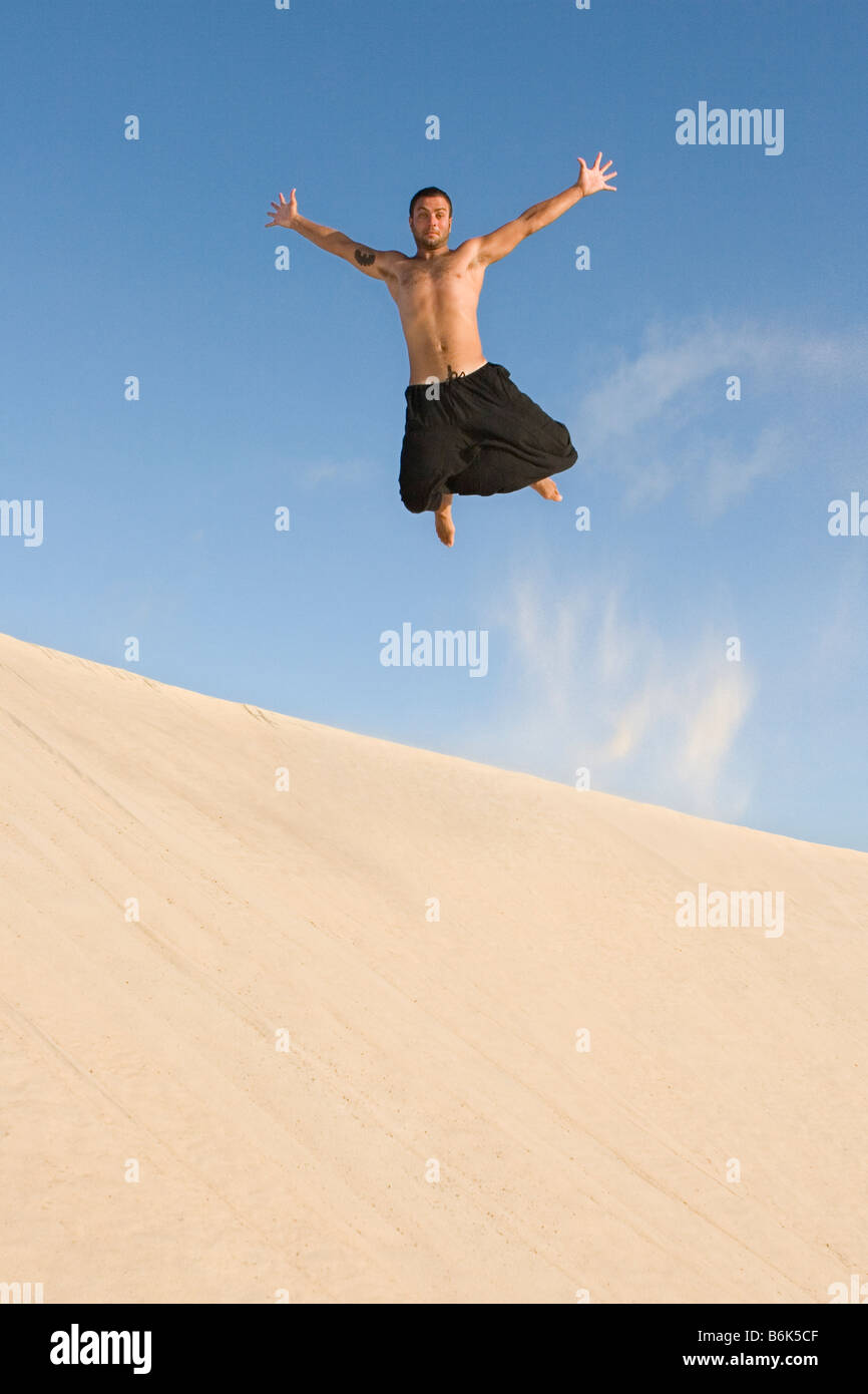 Man jumping above sand dune Stock Photo Alamy