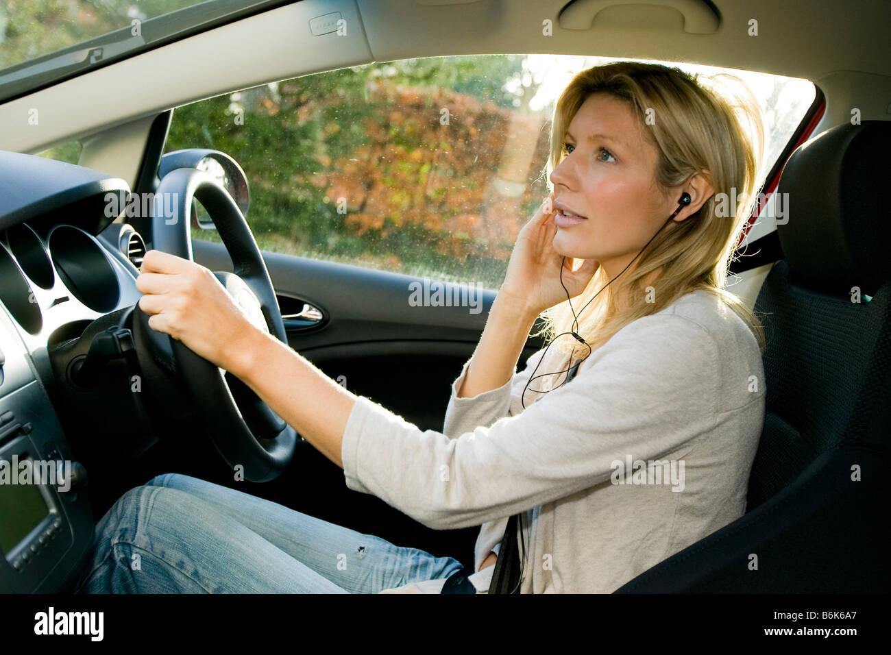 Woman using hands free phone in car Stock Photo
