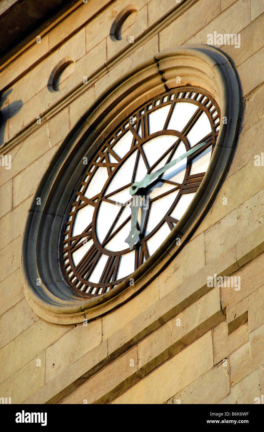 Clock face showing 6.15 time in roman numerals on clock tower of stone built town hall Stock