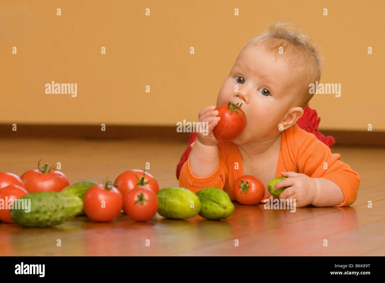 Five month old baby eating tomato Stock Photo Alamy