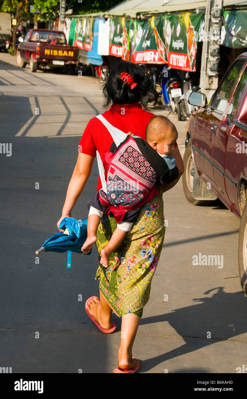 ethnic Karen woman from Burma carrying her baby in the market in Mae Sot Thailand Stock Photo