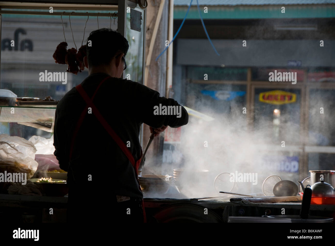 noodle vendor with steam and morning light in Mae Sot Thailand Stock Photo