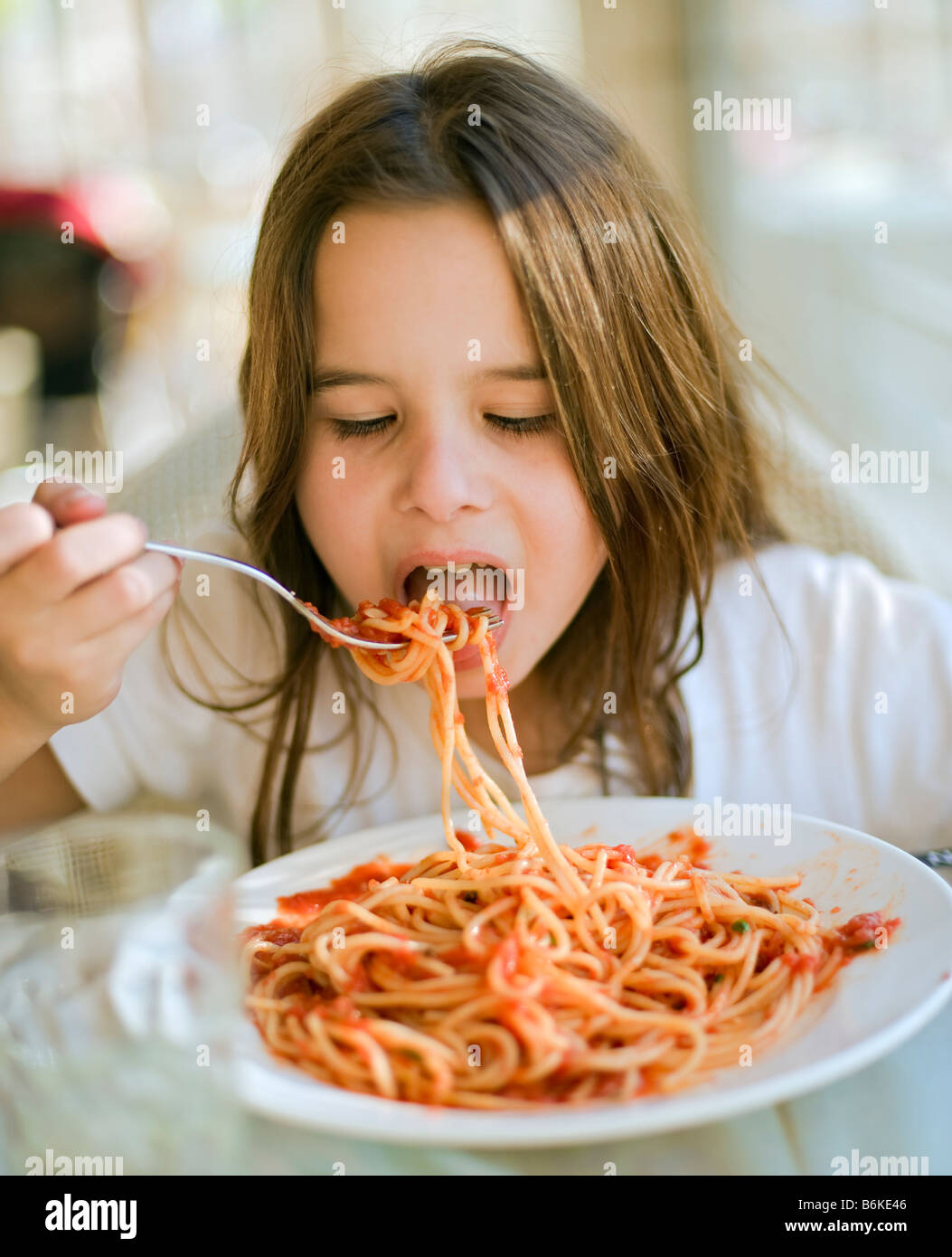 young girl eating spaghetti in restaurent Stock Photo Alamy