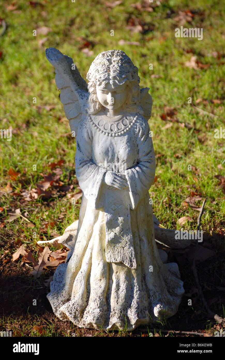 Angel statue with a broken wing in cemetery Stock Photo