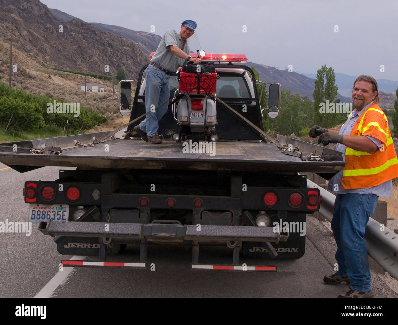 Robert Doc Morgan with his Vespa P200E loaded onto a flatbed truck by the side of US Highway 2 near Wenatchee Washington Stock Photo