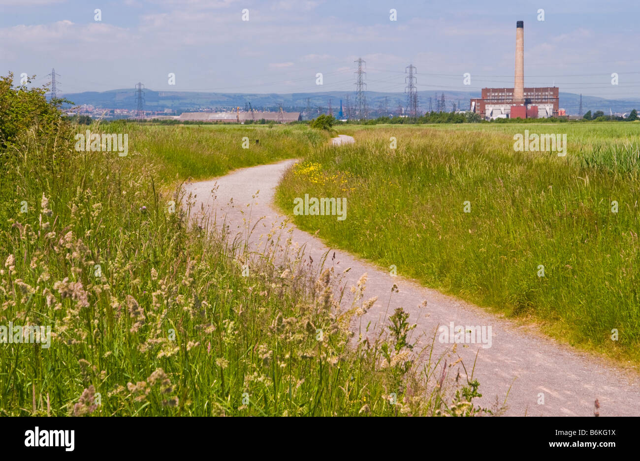 Footpath at Newport Wetlands National Nature Reserve South Wales UK looking toward power station Stock Photo