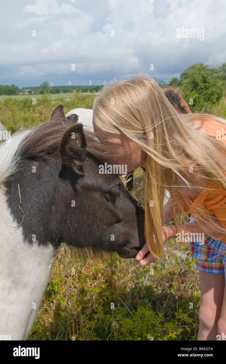 Girl kissing a Falabella pony. Stock Photo