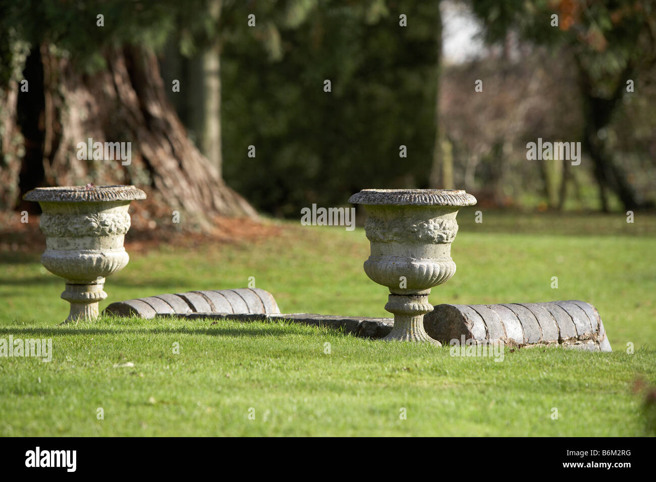 2 pair of stone vase vases or urn at the top of steps in the lawn Stock Photo