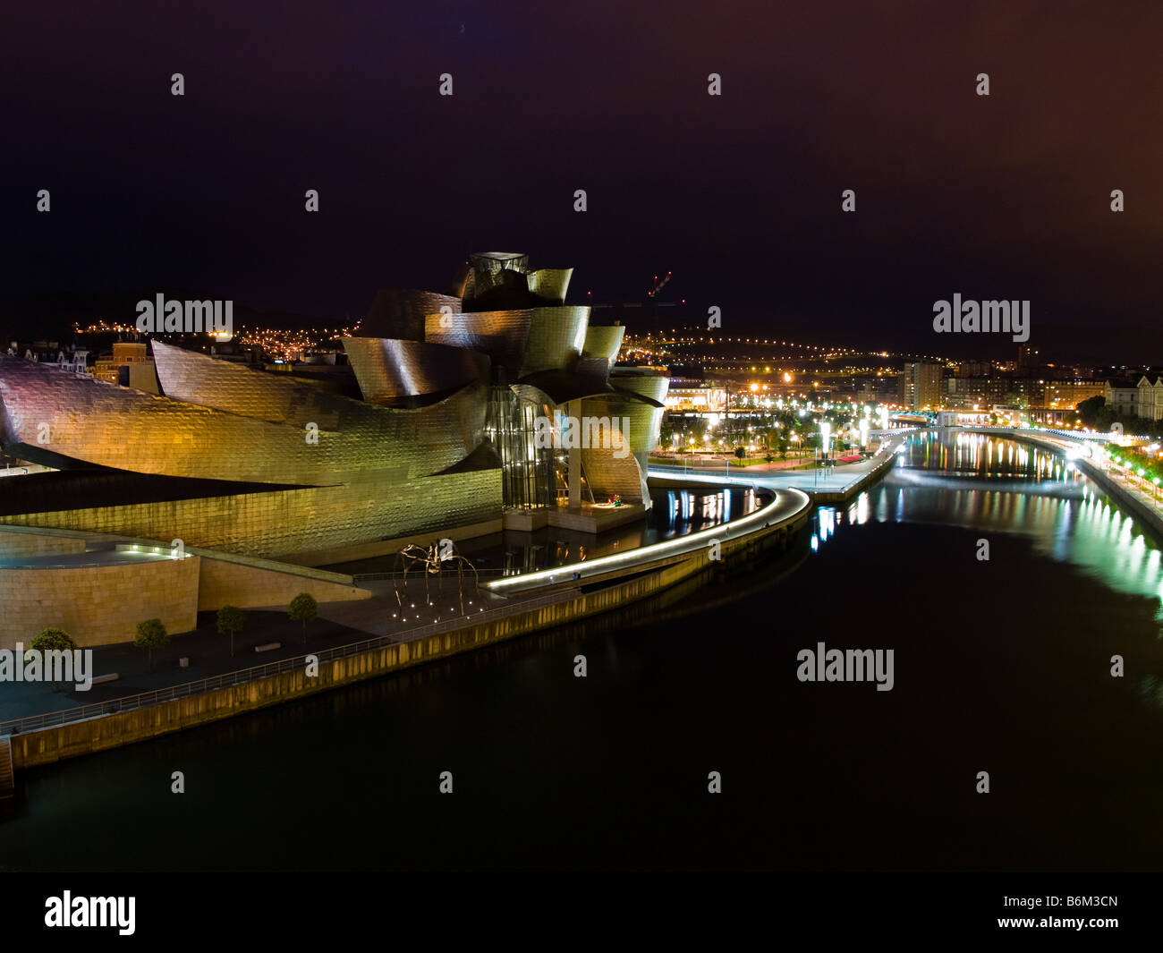 The magnificent Guggenheim Museum Bilbao, by Canadian architect Frank O. Gehry, glows at night. Stock Photo