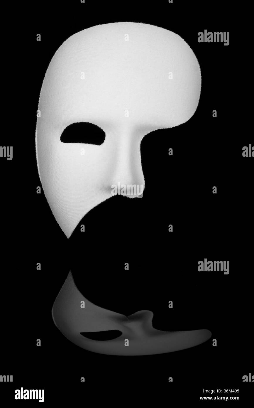 White phantom of the opera half face mask isolated on black background Stock Photo