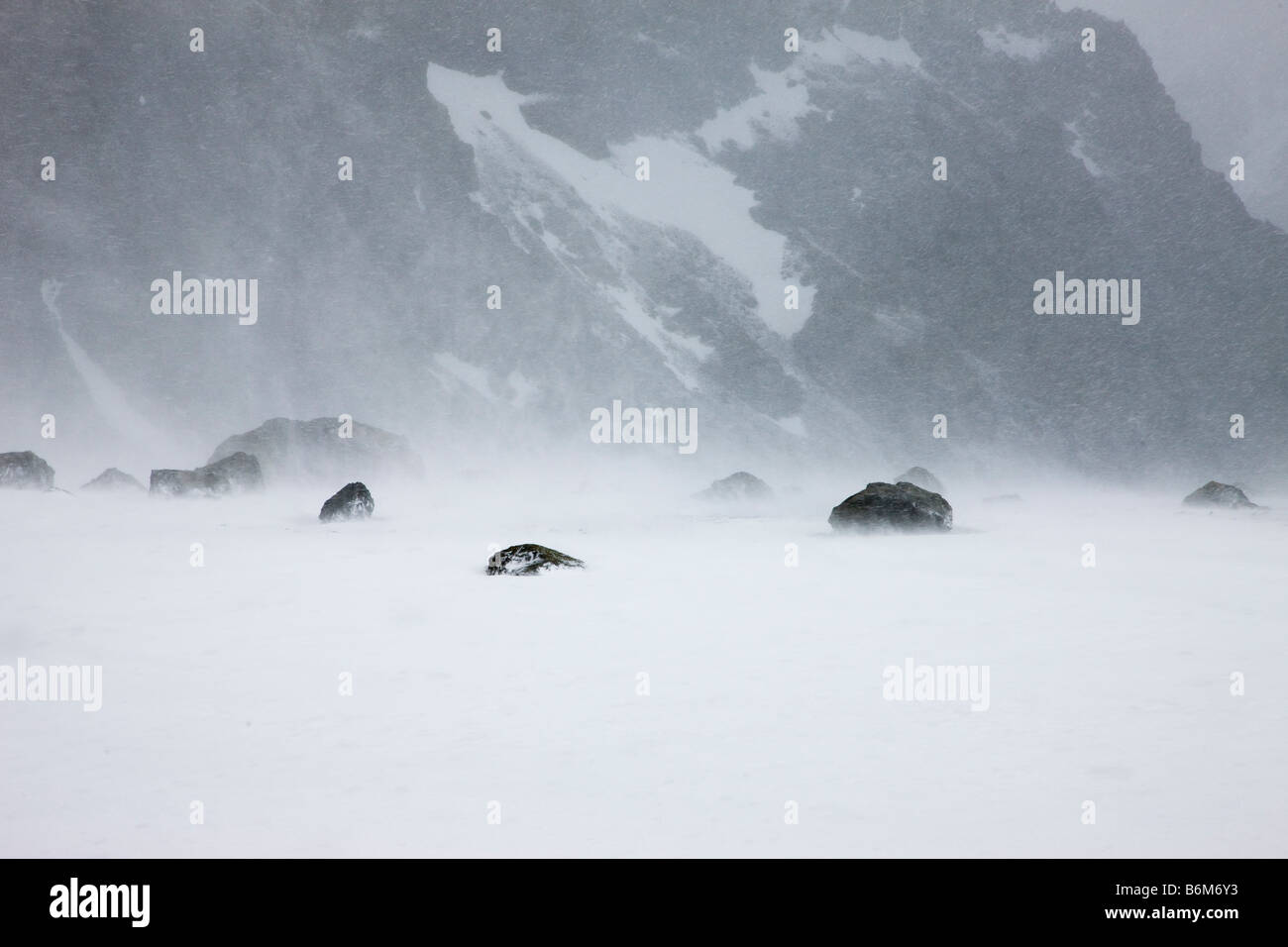 Windy Blowing snow storm and snow covered mountain in antarctic summer blizzard South Orkney Islands Antarctica white space Stock Photo