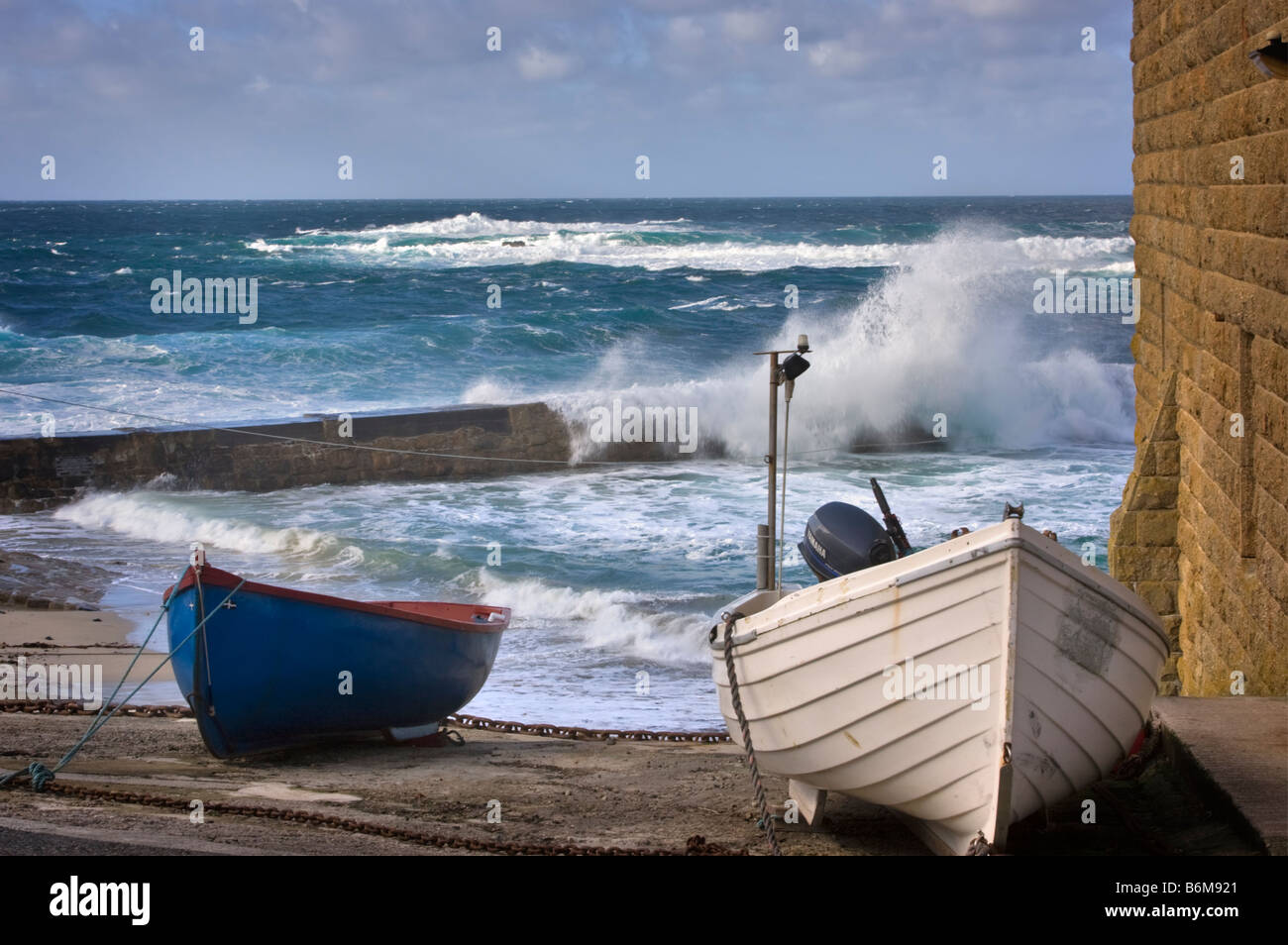 Fishing dinghies drawn up above the surf at Sennen Cove Cornwall Stock Photo
