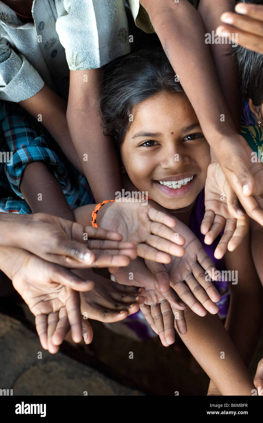 Indian girls smiling face amongst children playing together huddled in a group. Andhra Pradesh, India Stock Photo