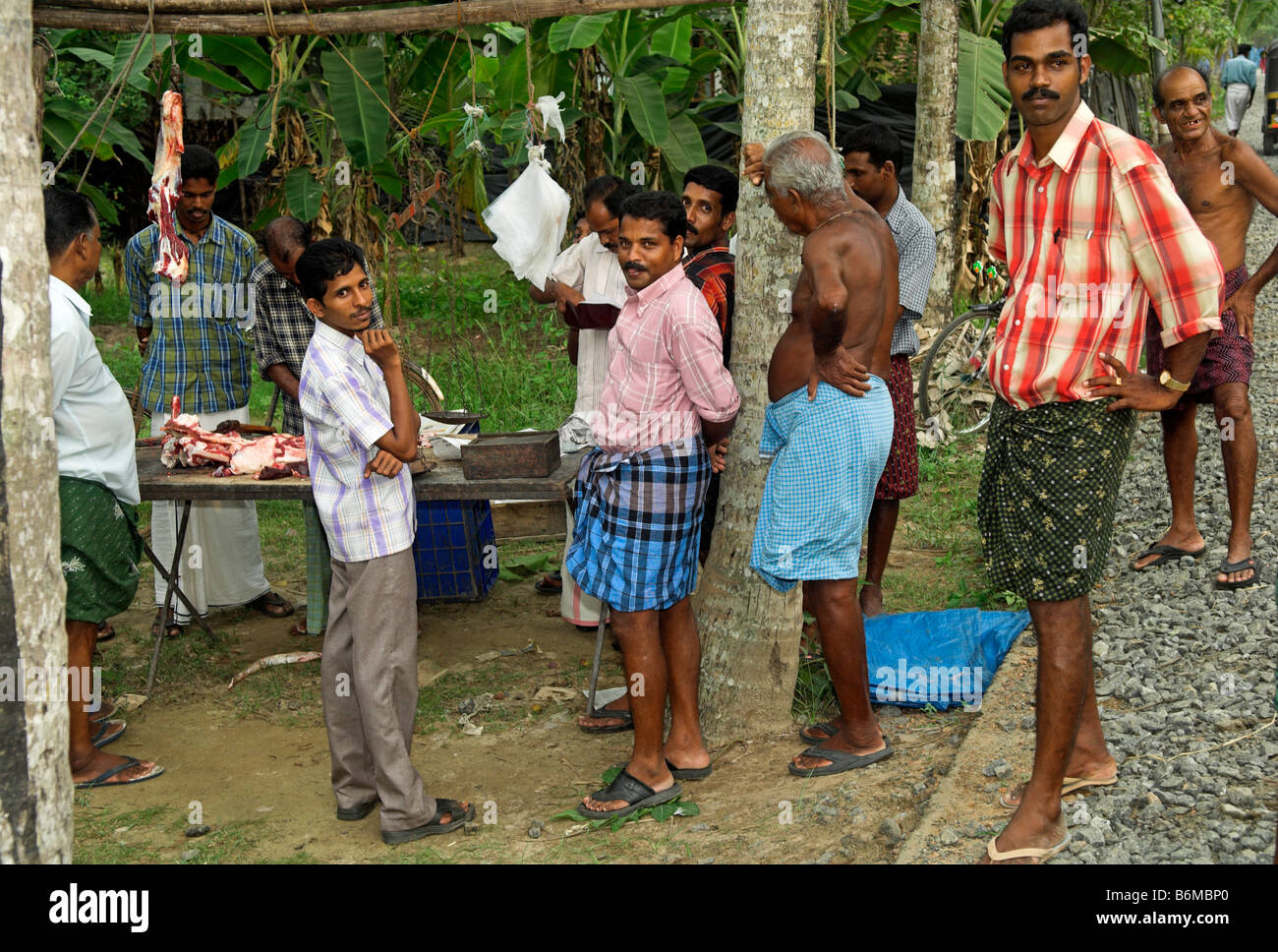 Customers in rural India waiting as meat is cut up Kerala India Stock Photo