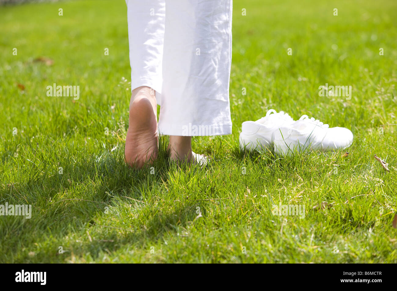 Young woman walking barefoot on the lawn Stock Photo - Alamy